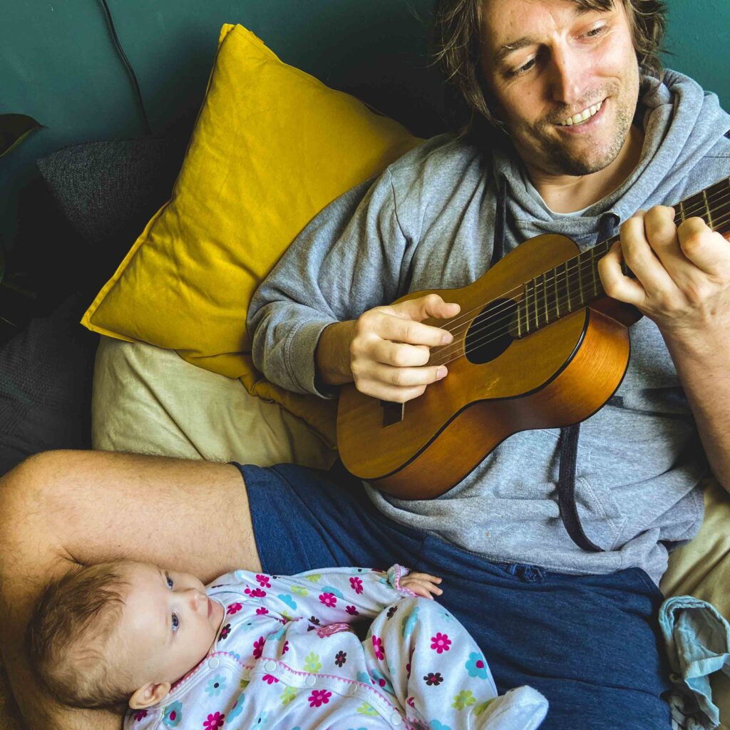 Owiwi with his daughter, playing guitar